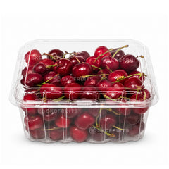 Clear plastic container filled with red cherries on a white background
