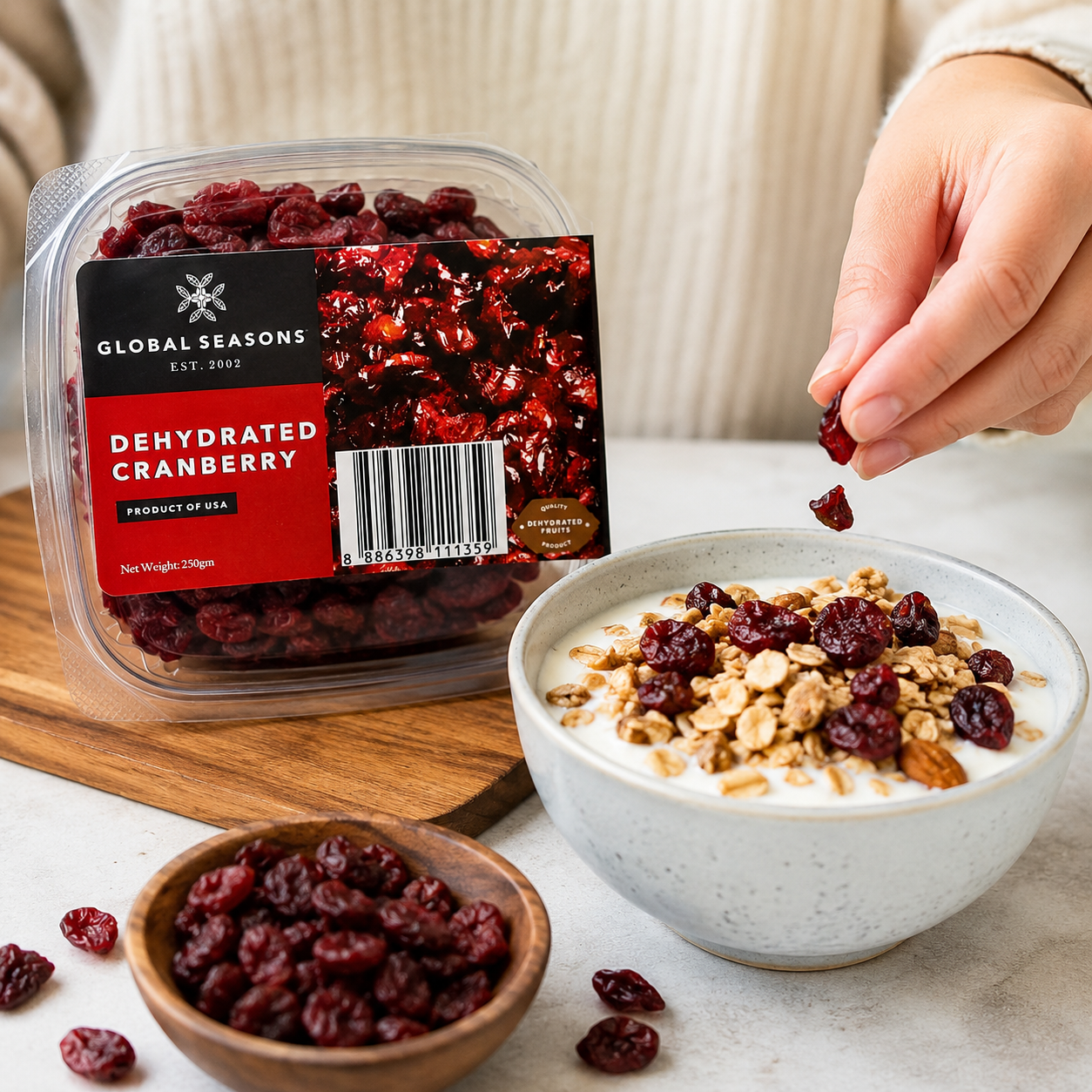 Dehydrated cranberries from Global Seasons being added to a bowl of yogurt and granola.