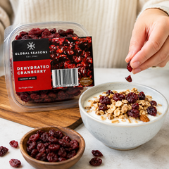Dehydrated cranberries from Global Seasons being added to a bowl of yogurt and granola.