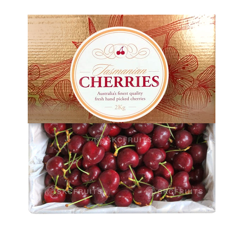 Packaging of Tasmanian Simone Cherries with a clear window showing the red cherries inside. The packaging has a decorative design with a combination of gold and red colors.