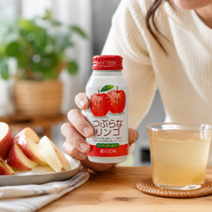 Person enjoying chilled Tsuburana Apple Juice as a refreshing Japanese drink