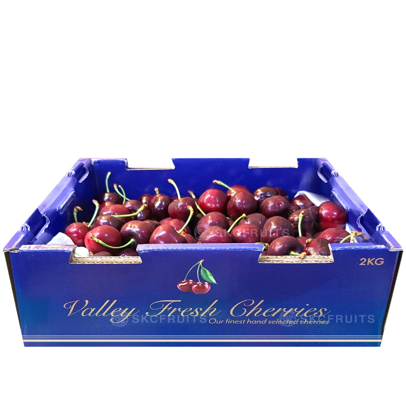 A box of Valley Fresh Red Cherries with a label indicating the brand and product details.