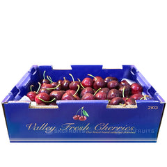 A box of Valley Fresh Red Cherries with a label indicating the brand and product details.