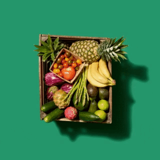 Fresh and bountiful assortment of fruits stacked in a box on a vibrant green background